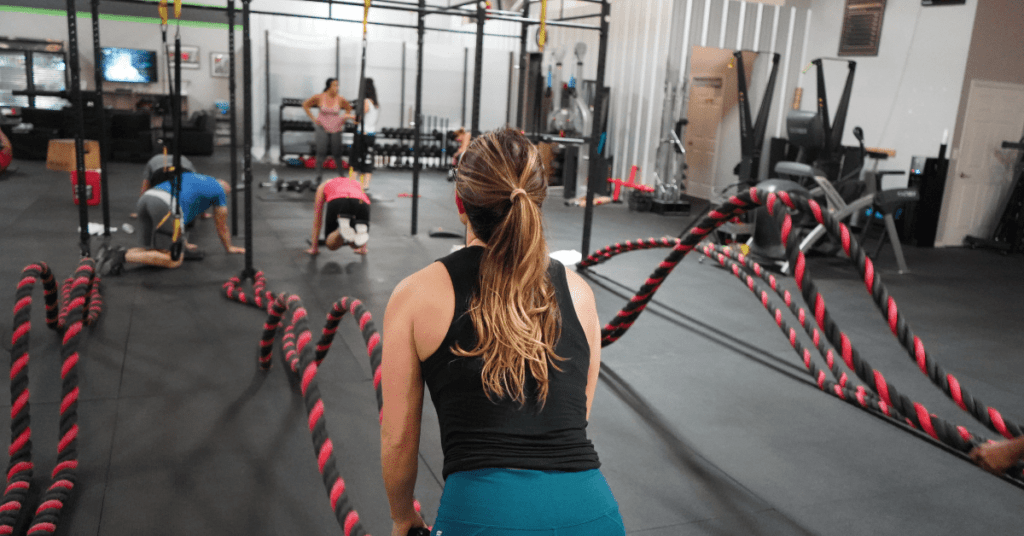 women on battle ropes in gym