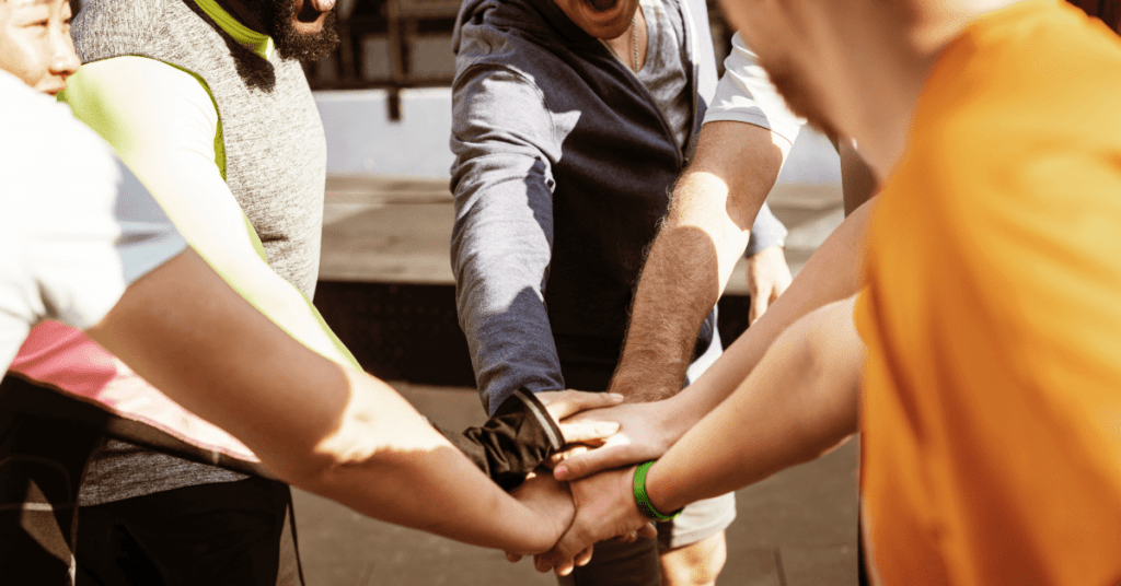 group of people putting their hands in