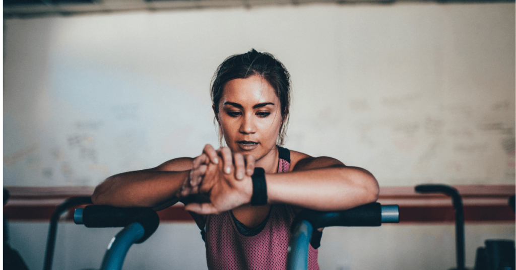 woman looking at a watch in the gym