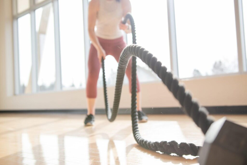 woman-exercising-with-battle-ropes-in-a-sunny-gym_t20_989NVy (1)