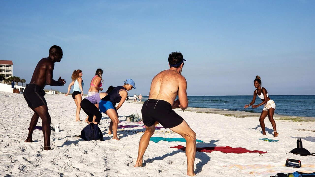 group exercising on beach group exercising on beach