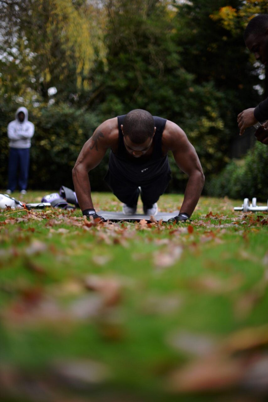 man doing a press up in a park man doing a press up in a park