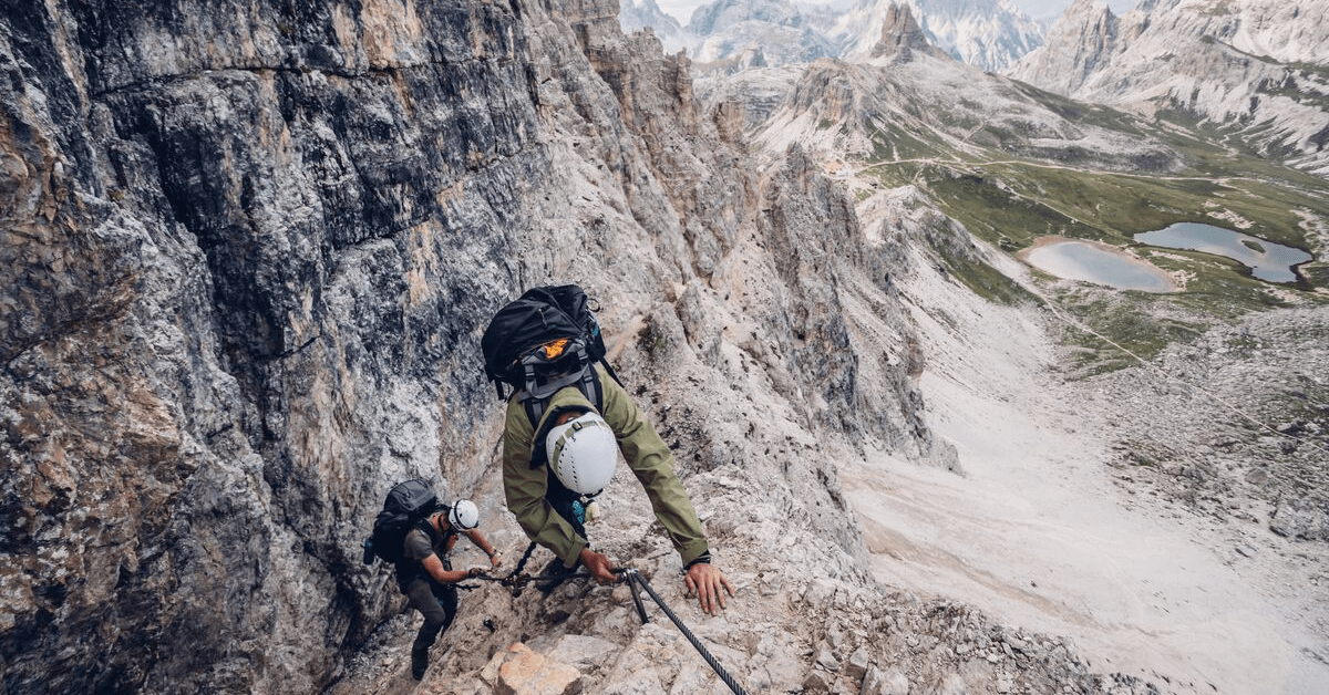 two men climbing a rock 