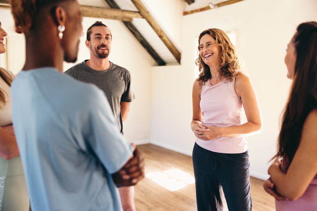 Group,Of,People,Talking,To,A,Yoga,Coach,While,Standing